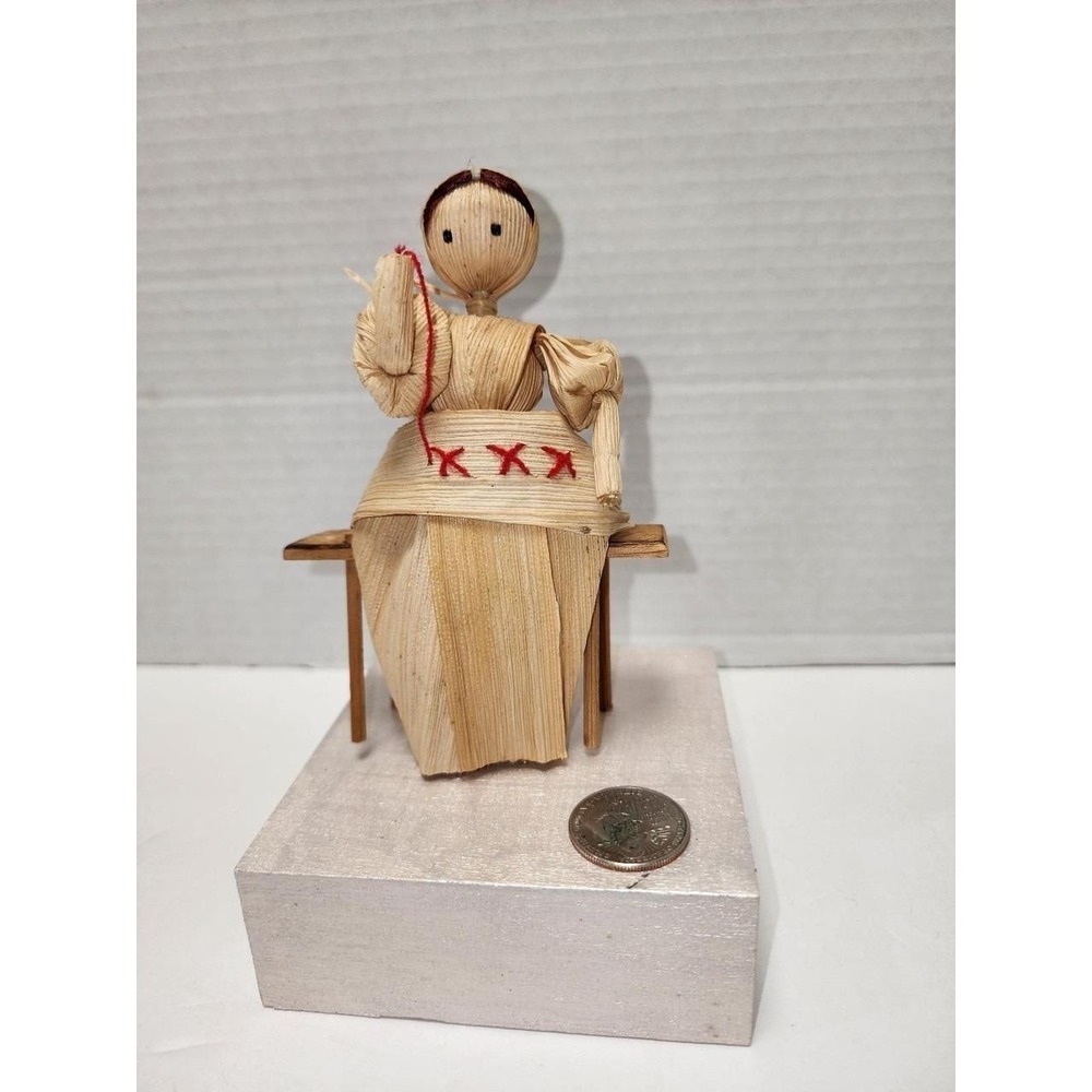 Hand sewing hand made corn husk Doll on bench traditional souvenir